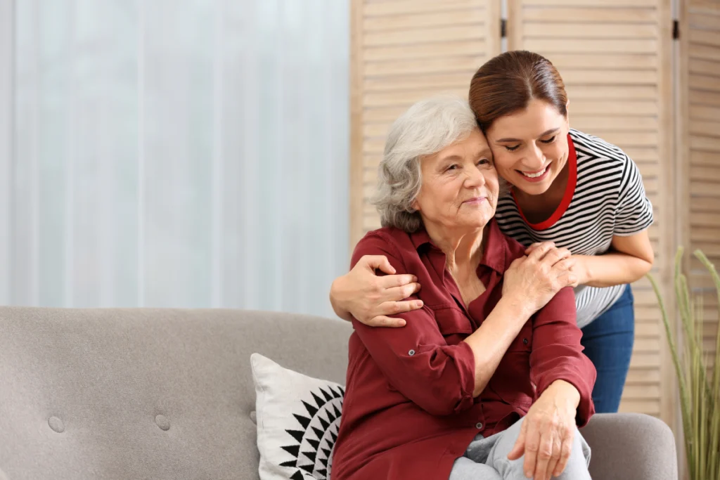 Senior woman embracing caregiver